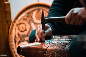 using a hammer to shape the copper